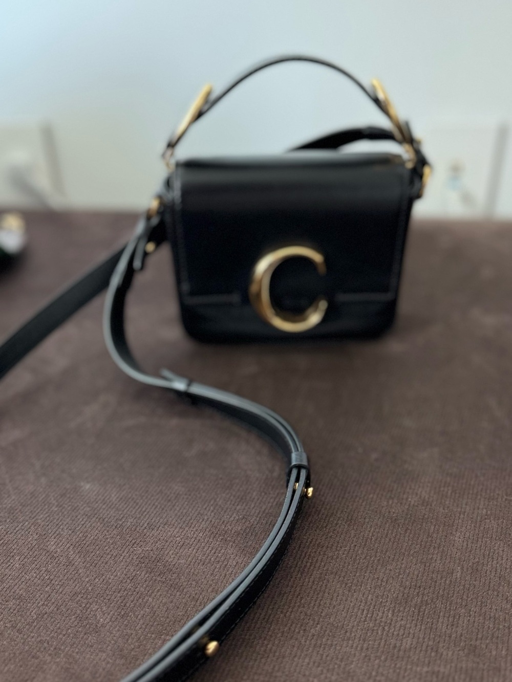 Black Leather Crossbody Bag with Gold 'C' Accent and Top Handle